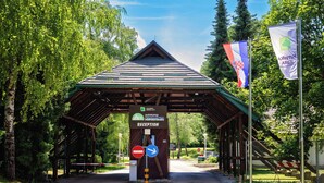 A reception area with a sign indicating 'autokamp KORONA' and a 'Reception' sign. There are flags on poles and a no-entry sign visible. - Kamp Korana (Rakovica)