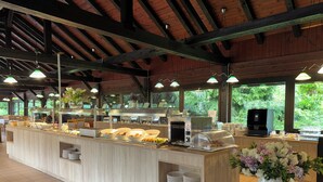 A buffet setup with a central serving counter, multiple food stations, and a coffee machine. - Kamp Korana (Rakovica)