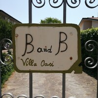 Un letrero con el texto 'Band B Villa Oasi' colocado en un portón de metal.
