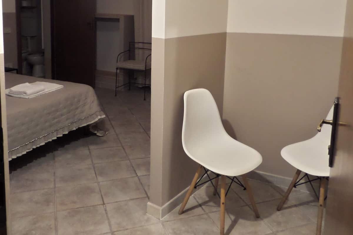 Une chambre d’hôtel avec un lit, une chaise et une petite table.