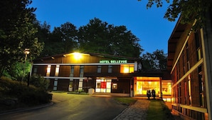 A hotel named HOTEL BELLEVUE with a modern design, featuring a well-lit entrance and a visible reception area.