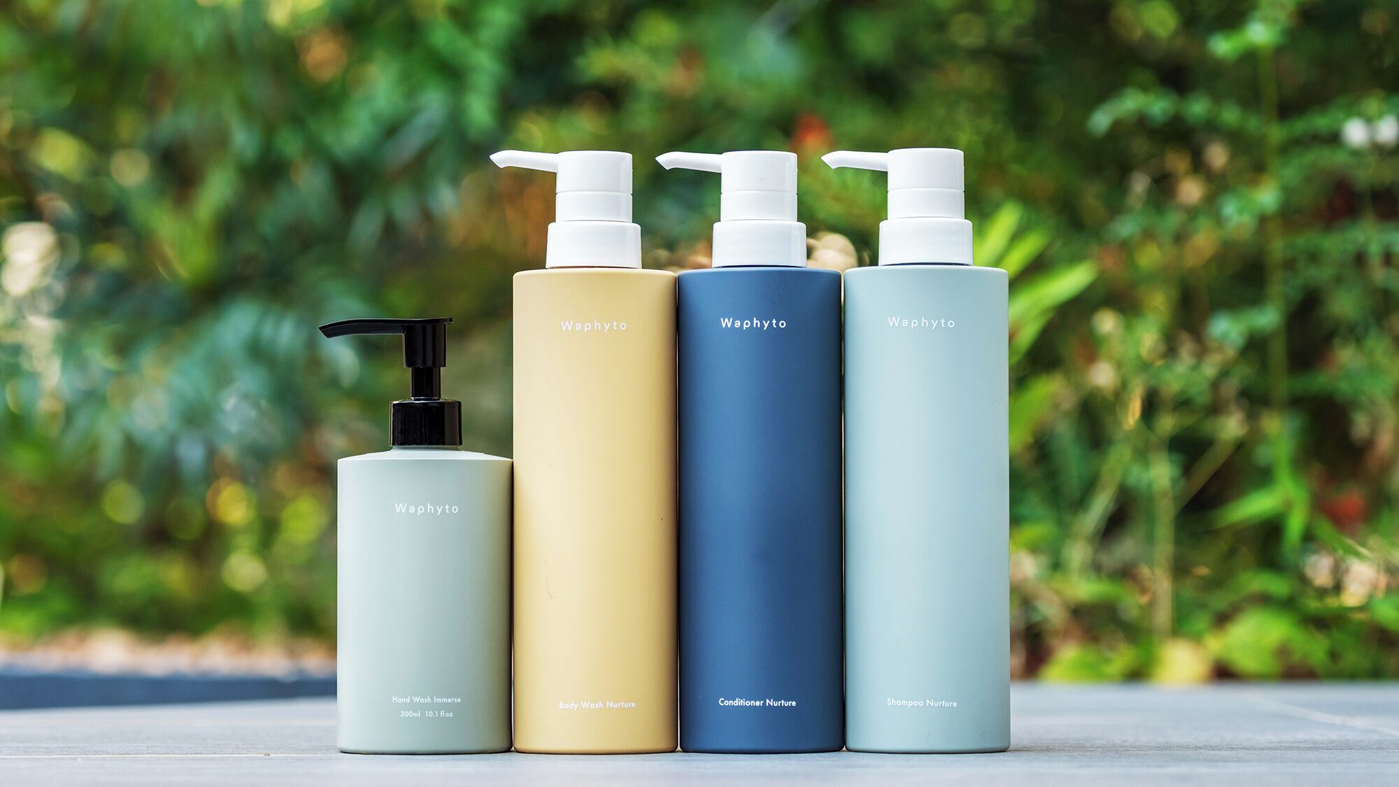 Four bottles of Waphyto personal care products with pump dispensers, each labeled with a different product name.