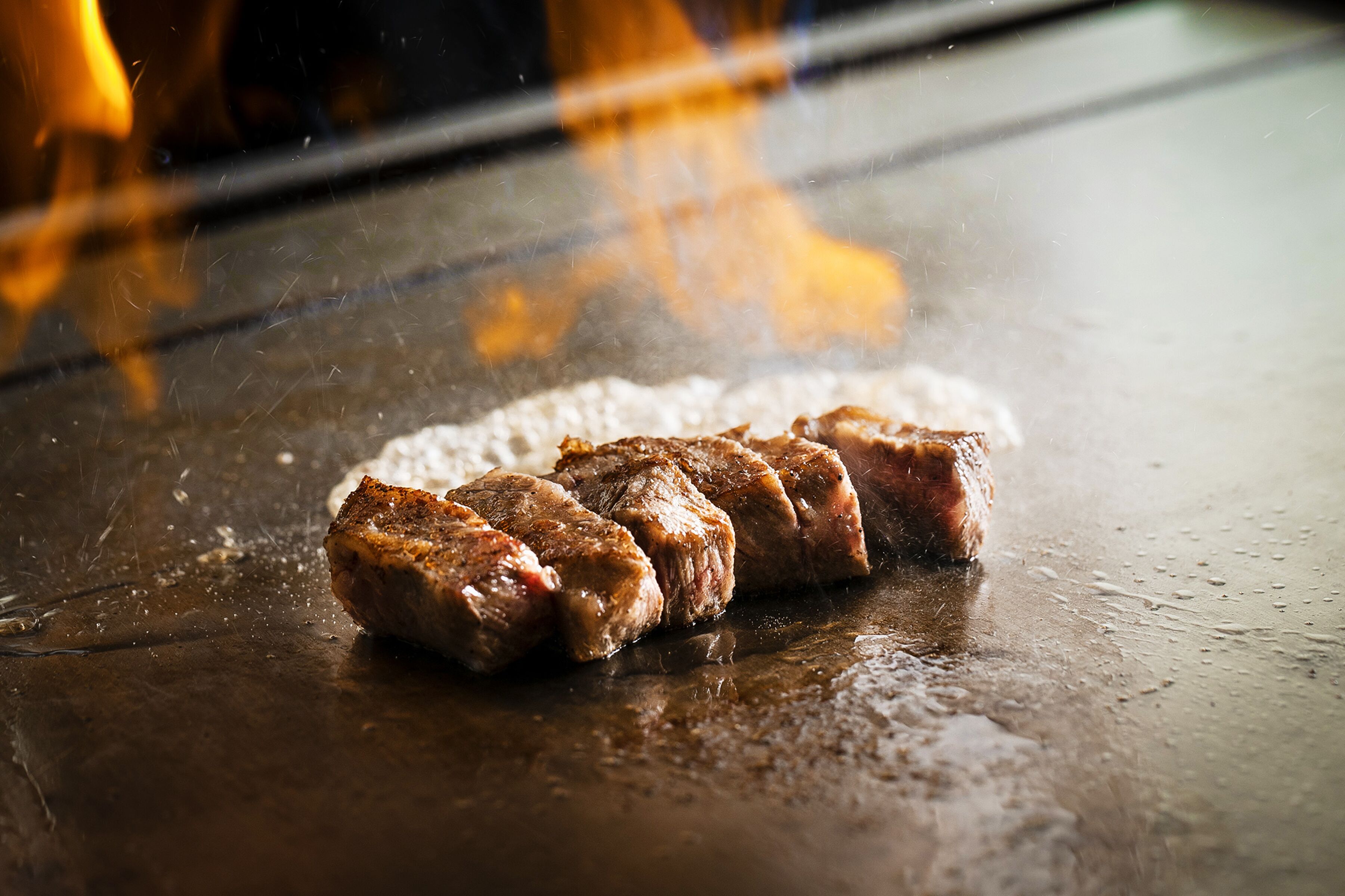 Una parrilla con varios trozos de carne asándose.