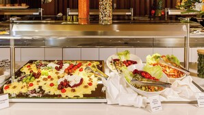 Buffet com diversas opções de comida e saladas.