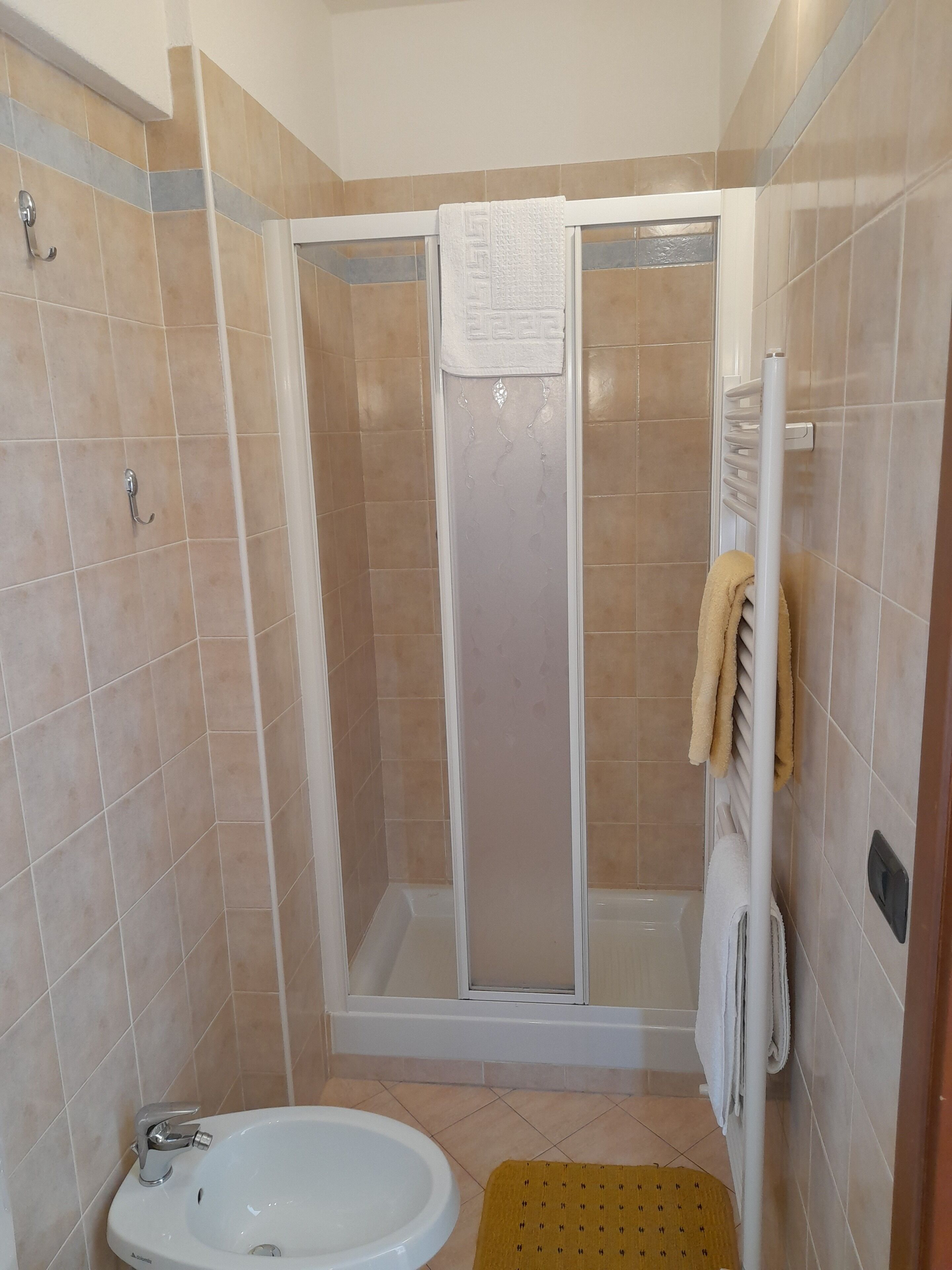 Un baño con ducha, bañera y lavamanos.