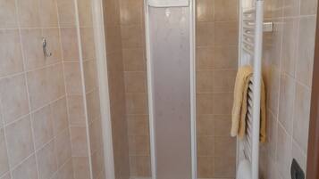 Un baño con ducha, bañera y lavamanos.