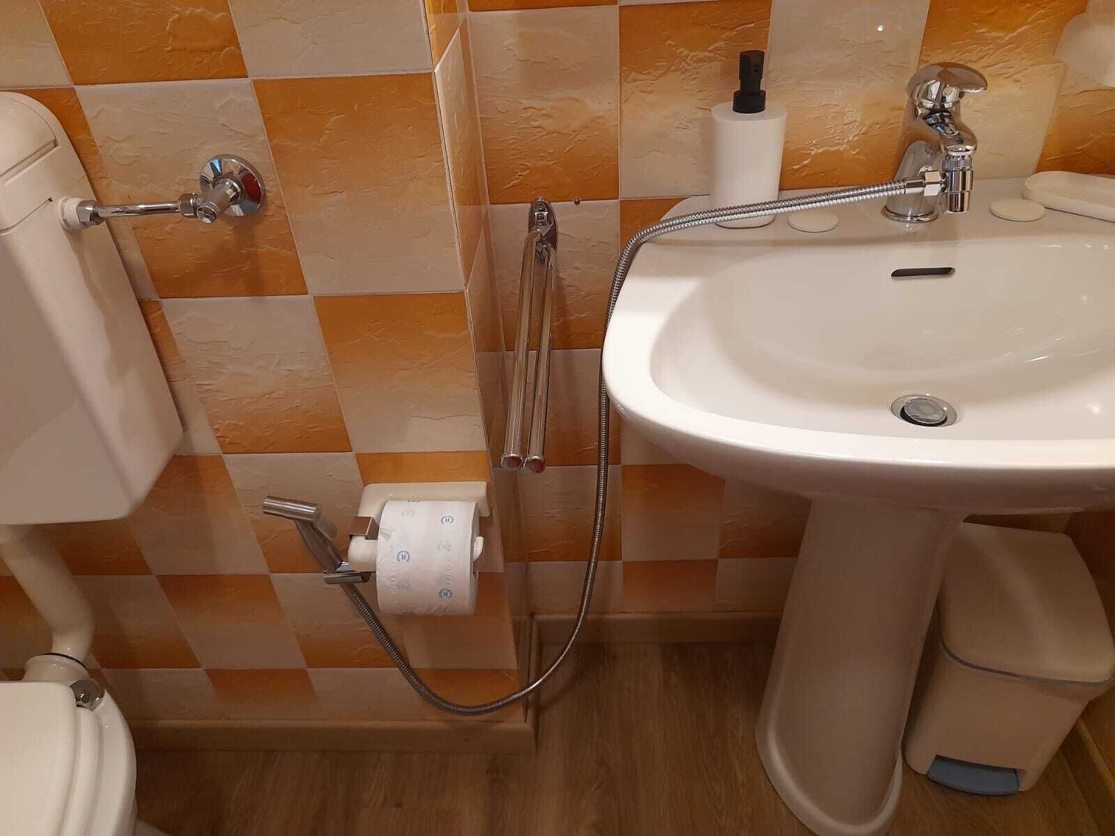 Un baño con inodoro, bidé y lavamanos.