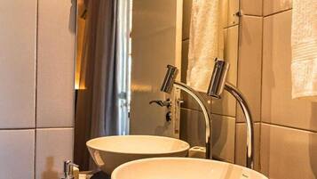 Chuveiro, toalhas de banho, sabonete, papel higiênico