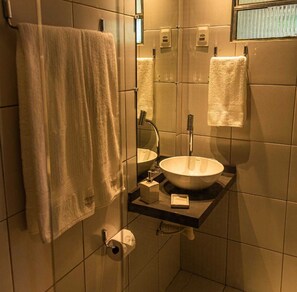 A bathroom with a white sink, a mirror, a towel rack, and a toilet paper holder. - Pousada Sunset Noronha (Fernando de Noronha)