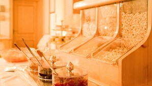Una mesa de buffet con múltiples dispensadores de comida y utensilios para servir.