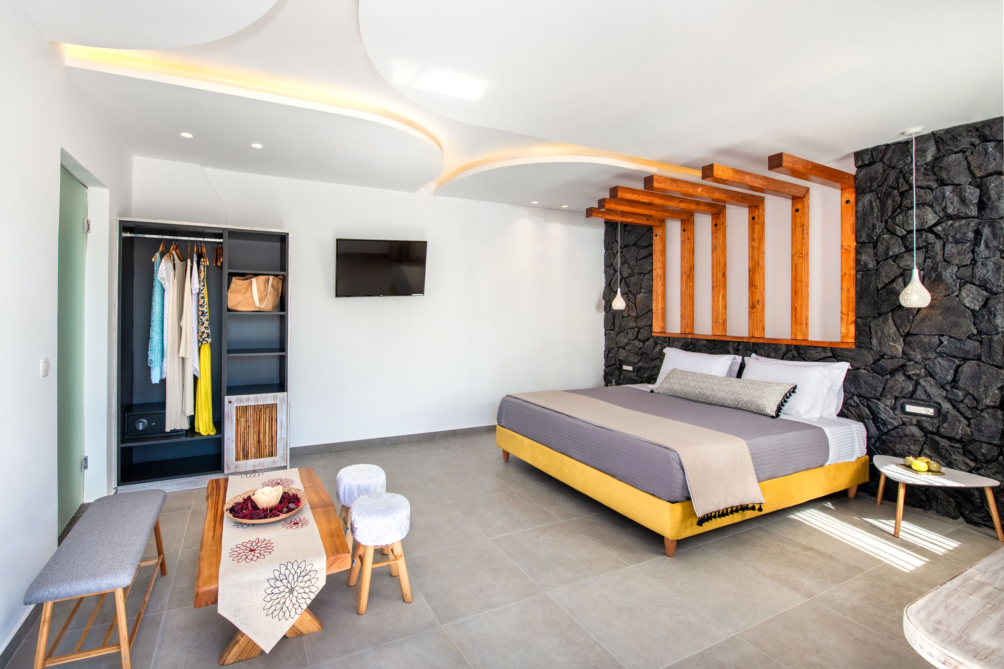 A modern bedroom with a bed, bedside table, and a wardrobe.