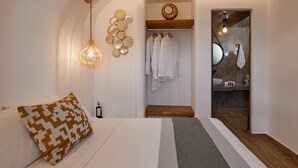 Ein modernes Schlafzimmer mit einem Bett, einer Pendelleuchte, einem an der Wand befestigten Spiegel und einer hölzernen Bank.