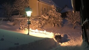 Eine schneebedeckte Kirche mit einem Glockenturm, beleuchtet von einer Straßenlaterne.