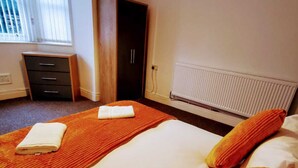 A hotel room with a bed, a radiator, a desk, and a wardrobe. - Belvidere Apartments by Top House (Liverpool)