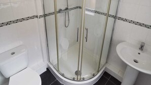 A modern bathroom with a glass-enclosed shower, a white toilet, and a pedestal sink. - Belvidere Apartments by Top House (Liverpool)