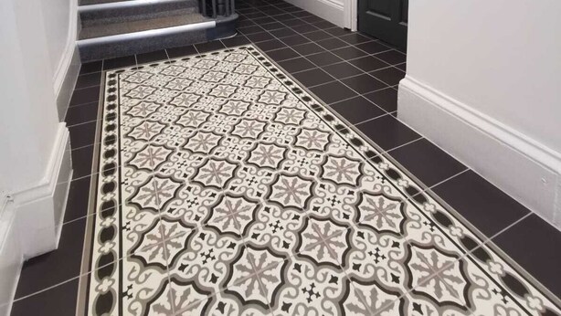 A hallway with a patterned tile floor, a staircase, and a door. - Belvidere Apartments by Top House (Liverpool)