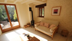 A cozy living room with a sofa, a wooden coffee table, and a fireplace.