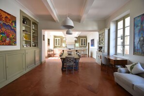 Una cocina amplia con comedor, que incluye una mesa grande y sillas, un armario empotrado e iluminación colgante.