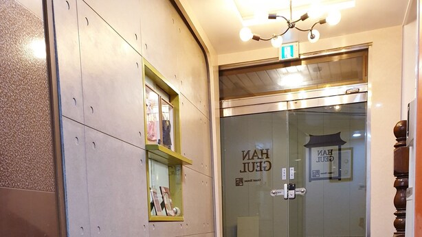 A hotel lobby with a reception desk, a glass door entrance, and a tiled floor. - Hangeul Guest House (Seoul)