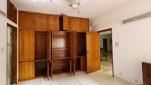 A spacious room with a large wooden wardrobe, a ceiling fan, and a tiled floor. - Daon Guest House Dhaka (Dhaka)