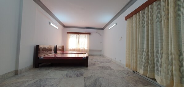 A bedroom with a bed, a window with curtains, and a ceiling light. - Daon Guest House Dhaka (Dhaka)