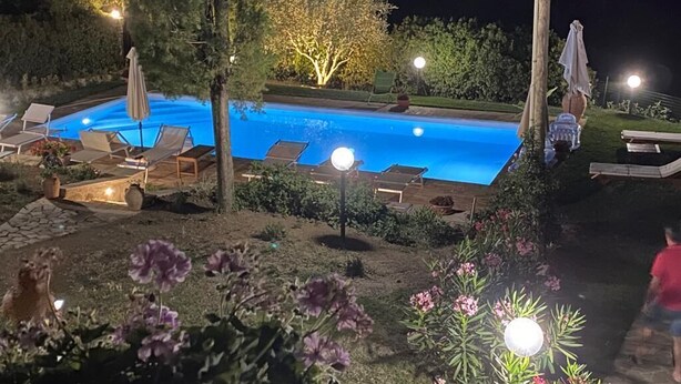 A swimming pool with lounge chairs and umbrellas, surrounded by well-maintained gardens and trees. - The casina of the NOT time downstairs (MONTEBUONO DI SORANO)