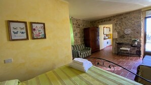 A room with a bed, a sofa, a dining area, and a kitchen in the background. - The casina of the NOT time downstairs (MONTEBUONO DI SORANO)