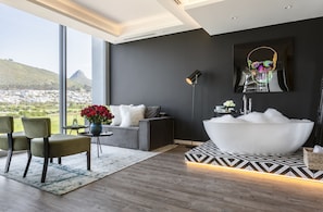 Une salle de bain moderne avec une grande baignoire, un mur noir et une vue sur le paysage urbain.