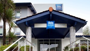 A modern hotel entrance with a sign indicating 'ibis budget hotels' and 'Biarritz-Anglet Airport' nearby. - Ibis Budget Biarritz Anglet (Anglet)
