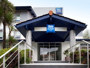 A modern hotel entrance with a sign indicating 'ibis budget hotels' and 'Biarritz-Anglet Airport' nearby. - Ibis Budget Biarritz Anglet (Anglet)