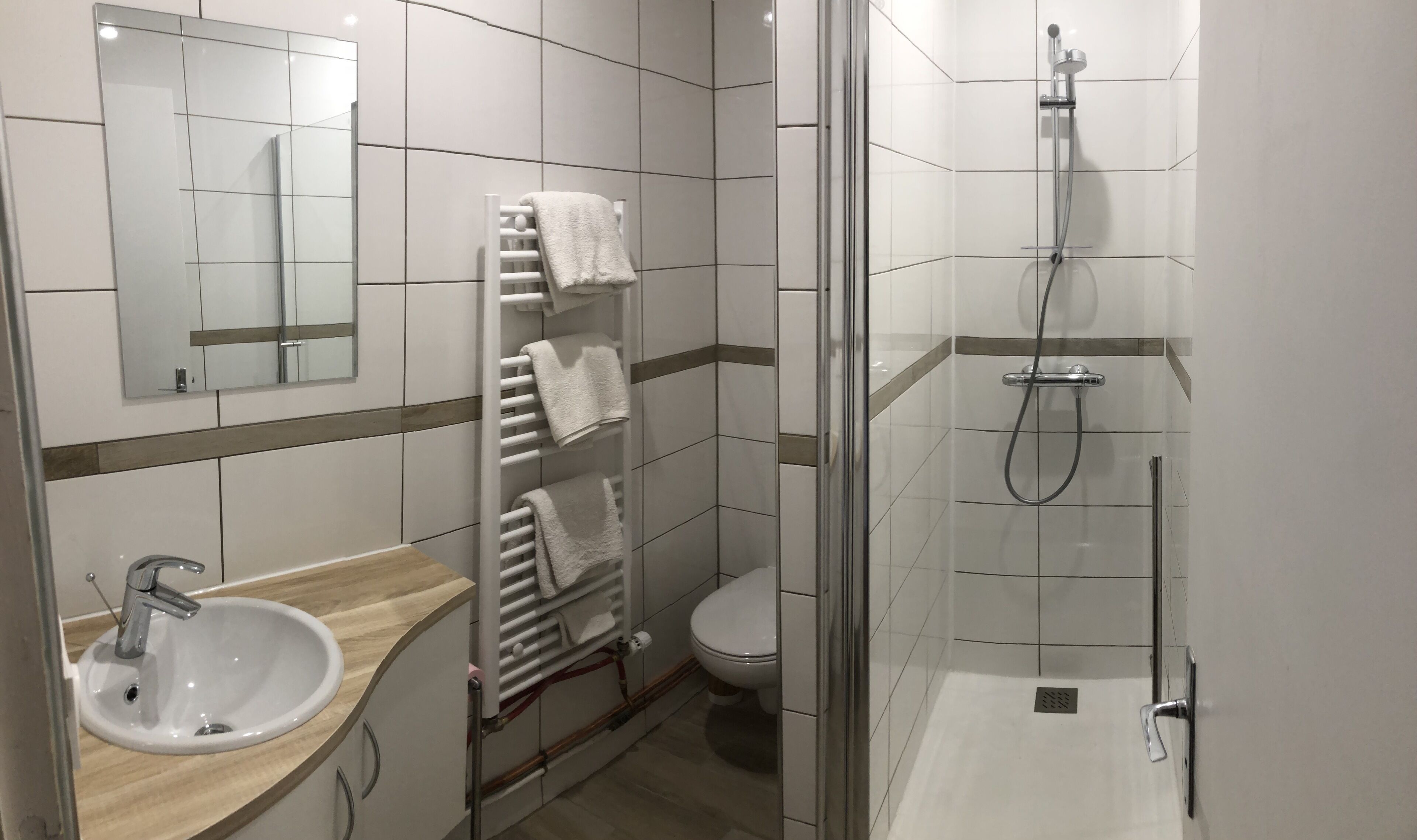 A modern bathroom with a sink, toilet, and shower.