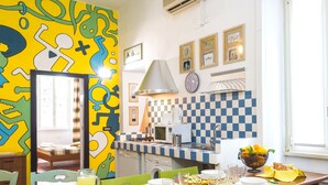 A dining area with a checkered backsplash, a mirror, and a window with curtains.