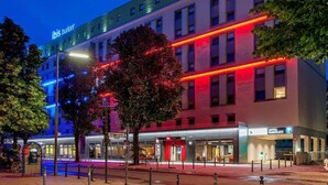 Ein modernes Hotel mit einem gut sichtbaren Schild mit der Aufschrift "ibis HOTEL", einem Schild mit der Aufschrift "HOTEL PARKPLAZA" und einem Eingang mit der Aufschrift "HOTEL PARKPLAZA".