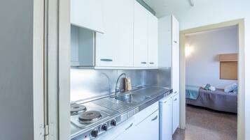 Vierpersoonskamer, 2 slaapkamers | Privékeuken | Een koelkast, een kookplaat, kookgerei, borden en bestek