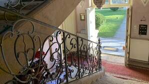 Una escalera con barandillas metálicas ornamentales que conduce a una puerta.