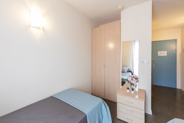 Une chambre à coucher comprenant un lit, une commode, un miroir et une armoire.