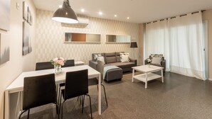 Een moderne woonkamer met een eethoek, een bank en een salontafel.