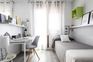 A modern bedroom with a desk, a bed, and a green shelf. - Residencia Universitaria Resa Barcelona Diagonal - Campus Accomodation (Barcelona)