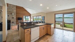A spacious kitchen with a stone wall, wooden cabinets, and a large island.
