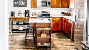 A modern kitchen with wooden cabinets, stainless steel appliances, and a central island.
