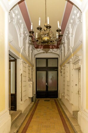 Enter through the beautifully appointed main entrance, featuring a patterned tile floor and elegant chandelier.