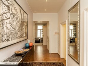 Enter a stylish hallway leading to a cozy living area with a console table and comfortable seating.