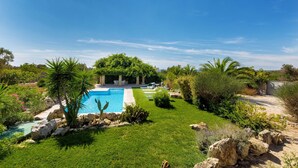 A private pool surrounded by lush greenery and rocks. - Villa Mila (Morciano di Leuca)