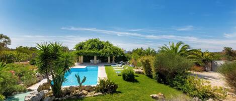 A private pool surrounded by lush greenery and rocks.