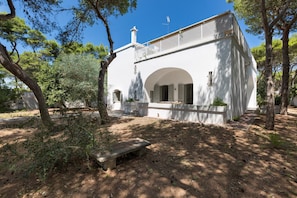 A white building with an arched entrance and a balcony.