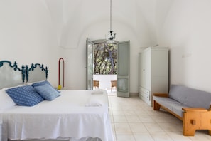 A bedroom with a bed, a wooden bench, and a wardrobe.