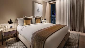 A hotel room with a large bed, a nightstand with a lamp, and a window with curtains.