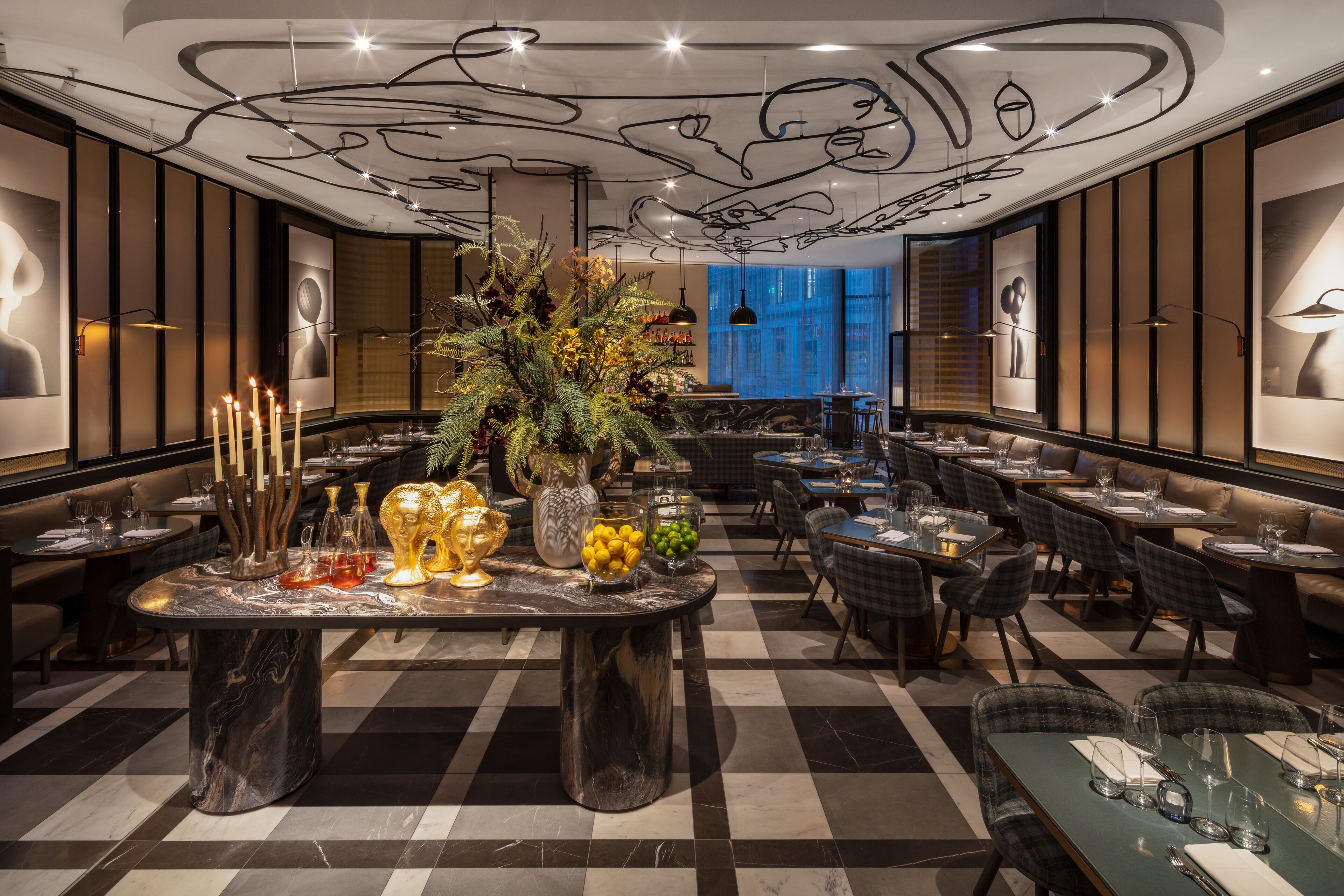 Un restaurante con suelo a cuadros, mesas de mármol y una decoración moderna.