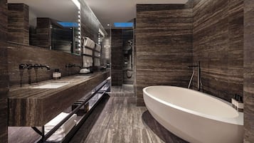 A modern bathroom with a large bathtub, a double sink vanity, and a walk-in shower.