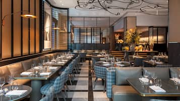 Un restaurante moderno con suelo a cuadros, asientos de cuero y una barra central.